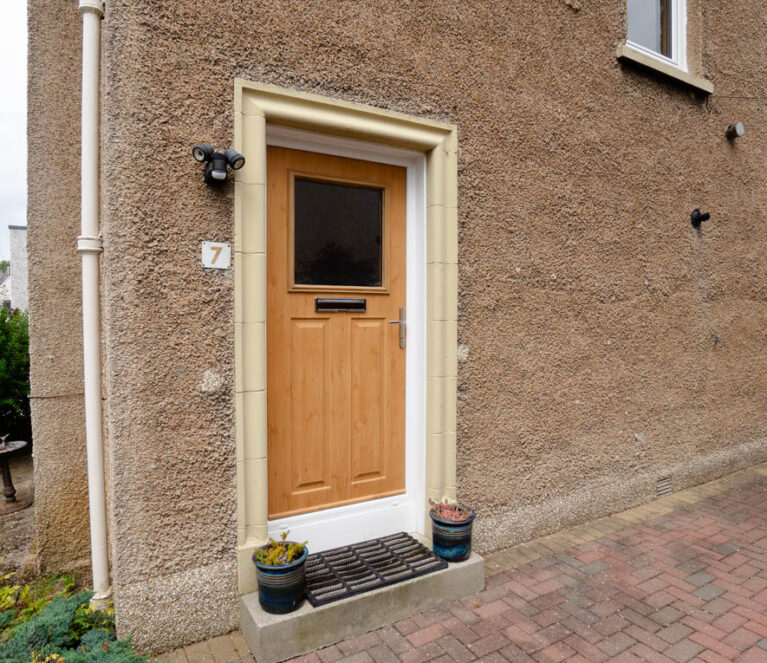 External view of golden oak front door with white frame