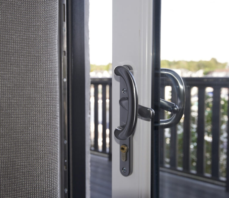Close up shot of a chrome handle on a sliding patio door.