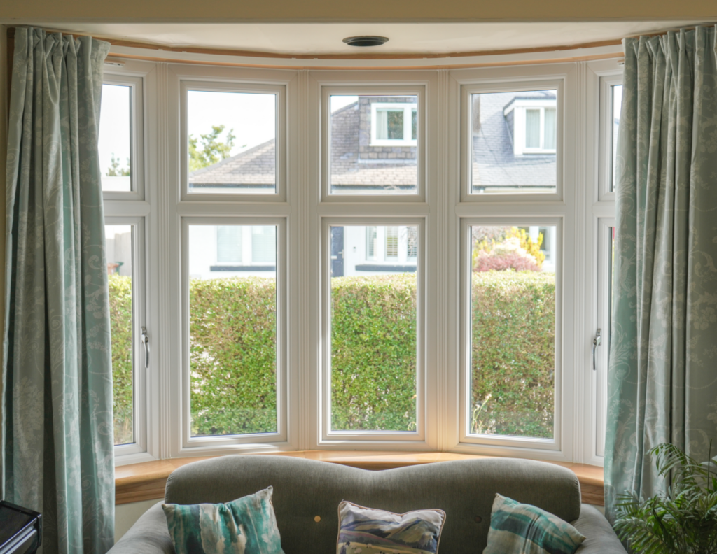 Living room, white uPVC casement windows in bay windows. Edinburgh home.