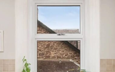 White Lorimer Casement window located abover the sink in the kitchen, with fixed bottom pane and top opener. Complete with internal white sills and surround.