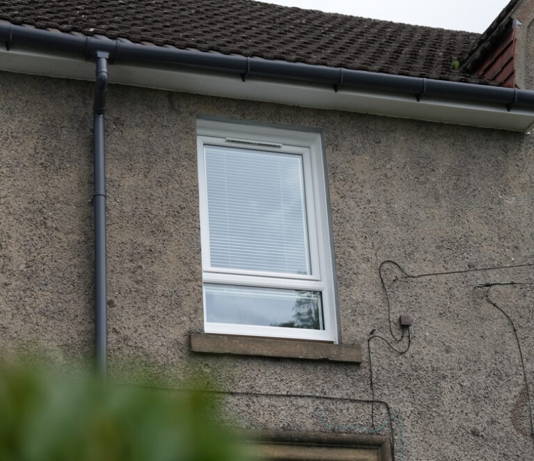 Exterior shot of upstairs windows. White Lorimer uPVC casement window complete with a fixed bottom pane.