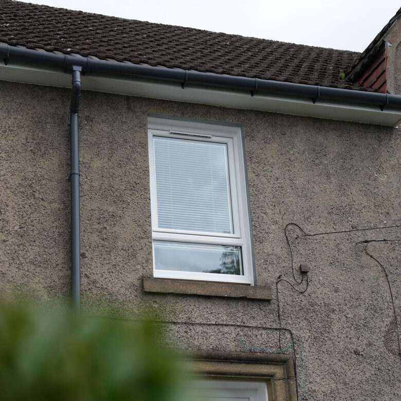 Exterior shot of upstairs windows. White Lorimer uPVC casement window complete with a fixed bottom pane.