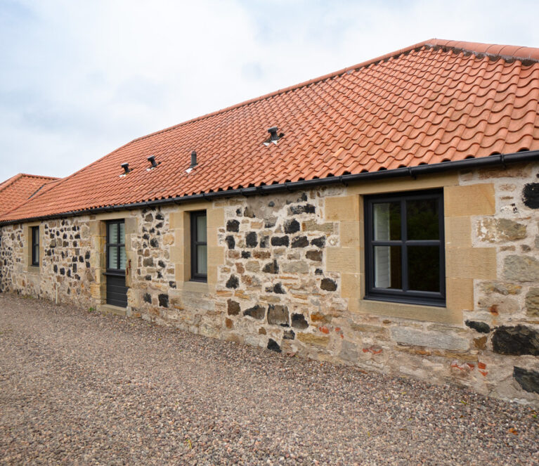Rear exterior of traditional cottage with anthracite grey Lorimer casement windows
