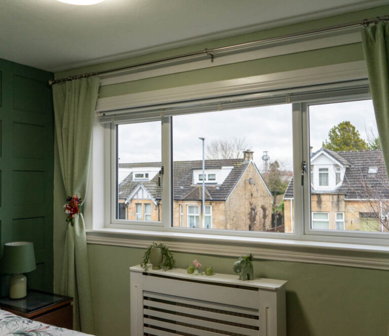 Interior view of white Lorimer casement windows overlooking the garden in Wishaw, Glasgow.