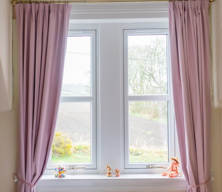 Interior view of white Lorimer casement windows overlooking the garden in Fife