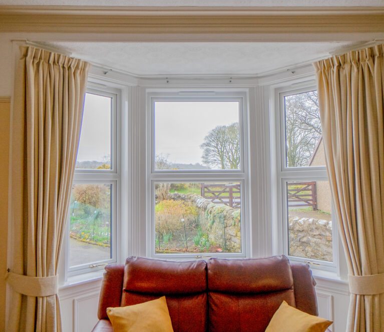 Interior view of white Lorimer casement windows overlooking the garden in Fife.