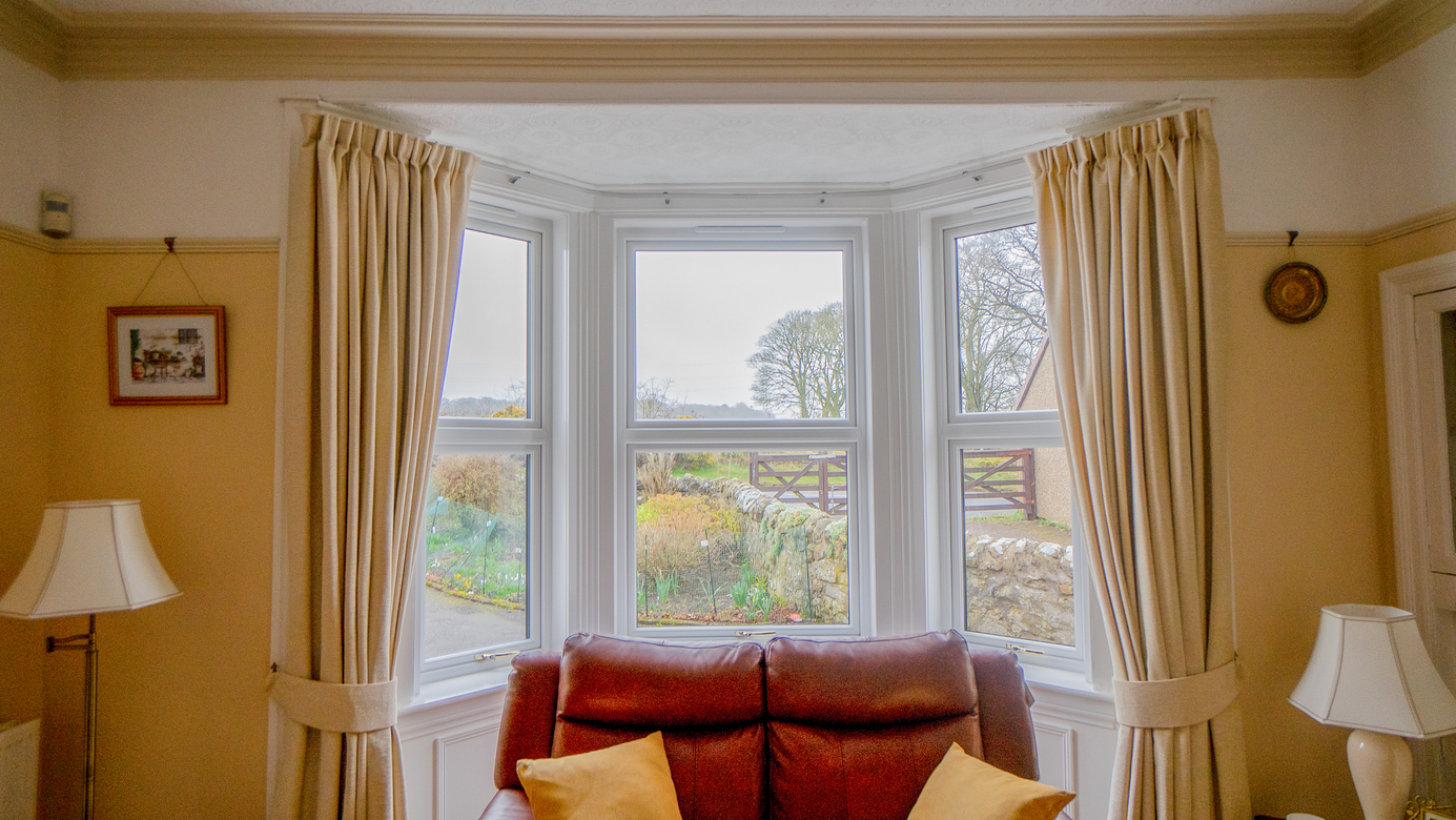 Interior view of white Lorimer casement windows overlooking the garden in Fife.