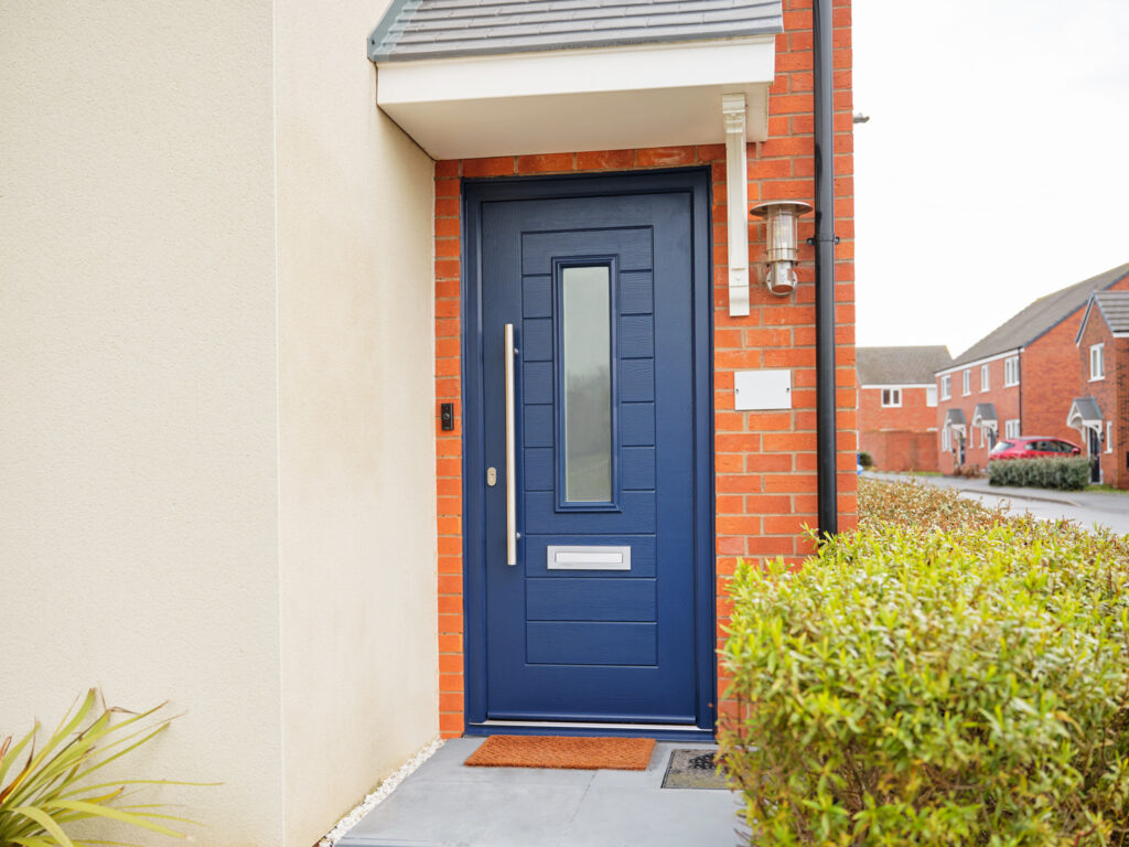 Exterior shot of a TimberLuxe front door in French Navy, complete with a graphite pull bar handle.