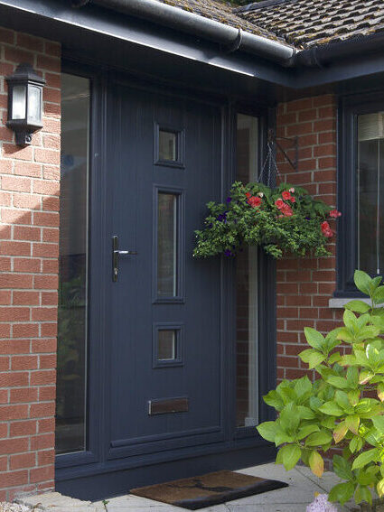 Exterior shot of a front door in an anthracite finish. Complete with two frosted glass side screen
